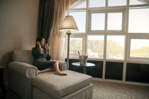tbh-hotel-signal-hill-suite-model-drinking-champagne-enjoying-view-of-table-mountain-from-room-sus